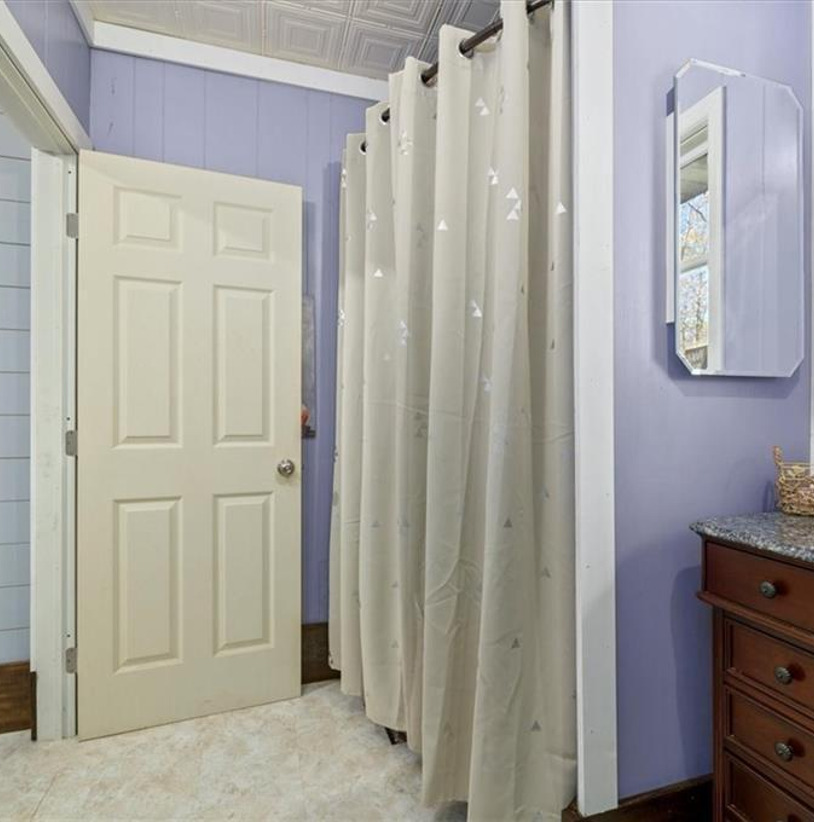 bathroom with dual mirrors, vanity, and shower curtain
