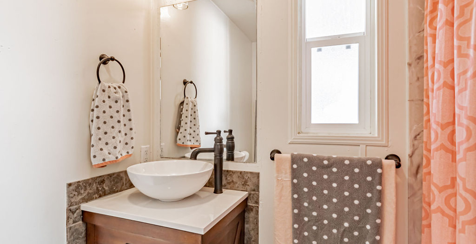 bathroom featuring natural light, tile flooring, mirror, vanity, and shower curtain