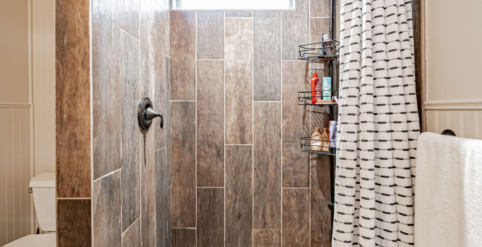 bathroom with toilet, shower curtain, and a shower