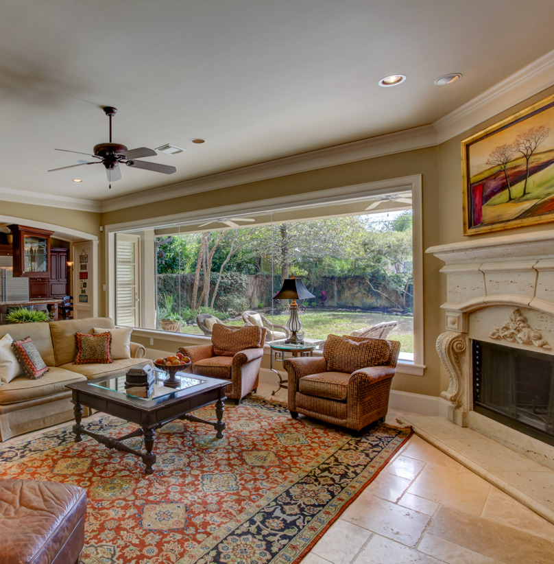 living room with a ceiling fan, tile flooring, natural light, and a fireplace