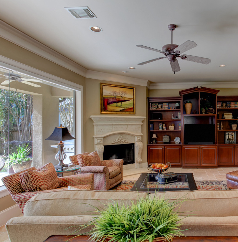 living room with a ceiling fan and a fireplace