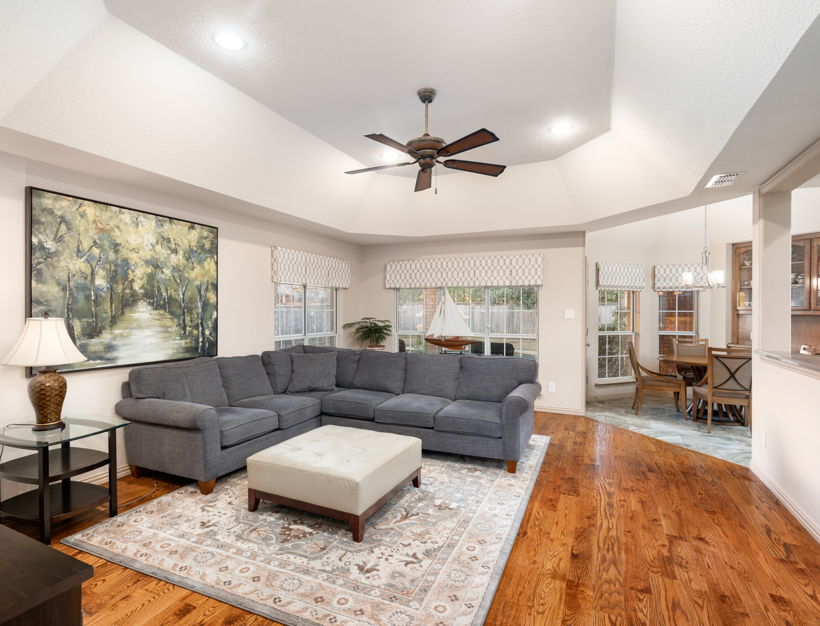 living room featuring hardwood floors, a ceiling fan, and natural light