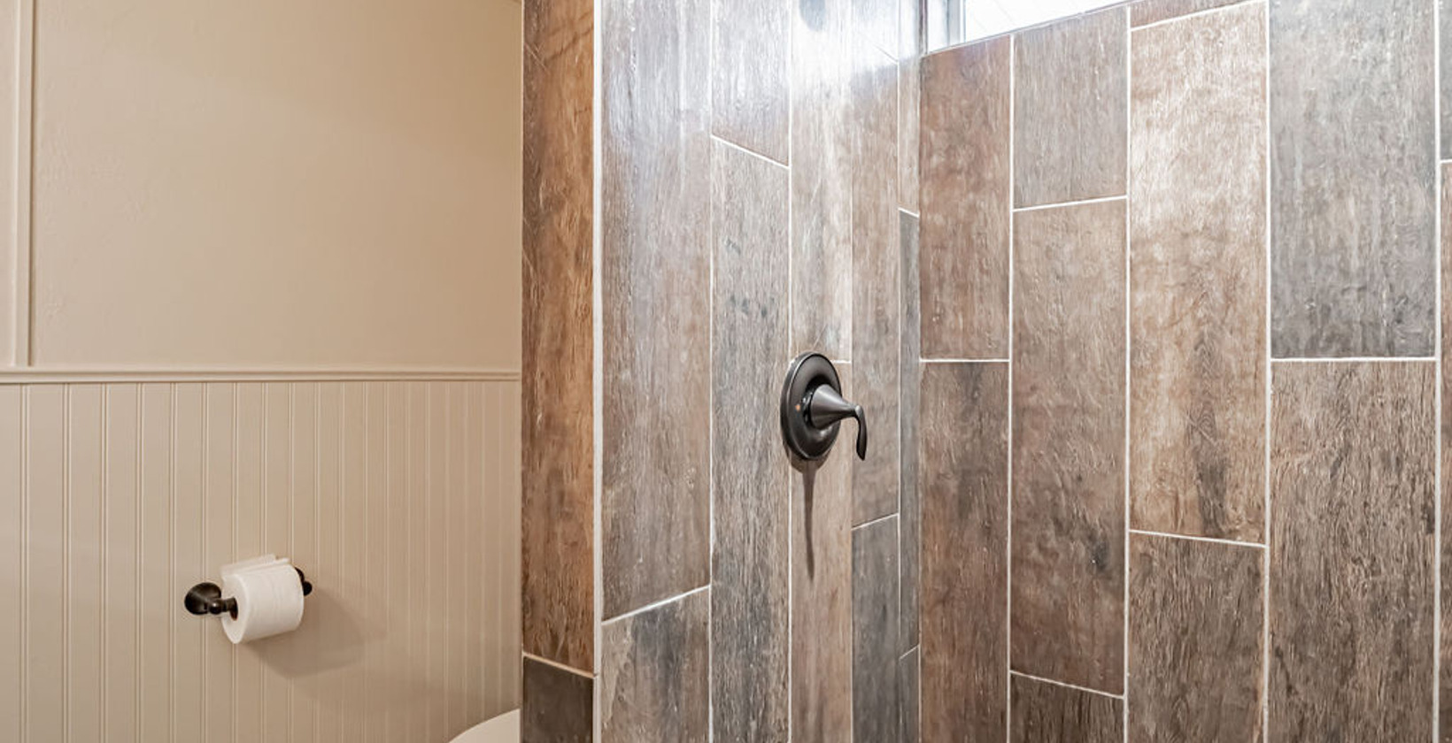 bathroom with tile floors, toilet, and a shower
