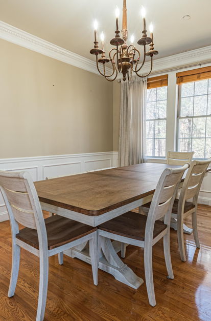 tiled dining room featuring natural light, a kitchen bar, and a chandelier