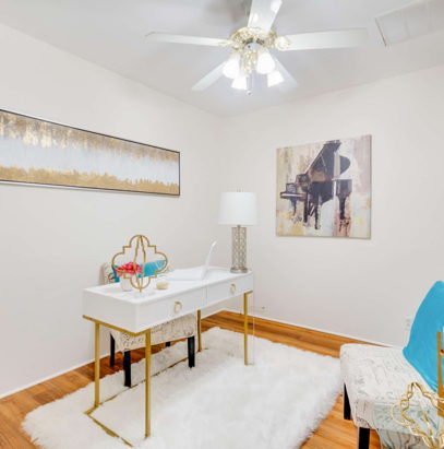 wood floored home office with a ceiling fan