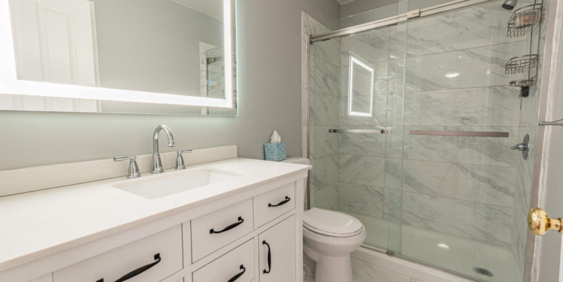 full bathroom with shower with glass door, vanity, toilet, and mirror