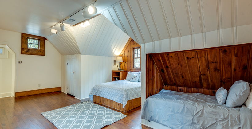 hardwood floored bedroom with lofted ceiling